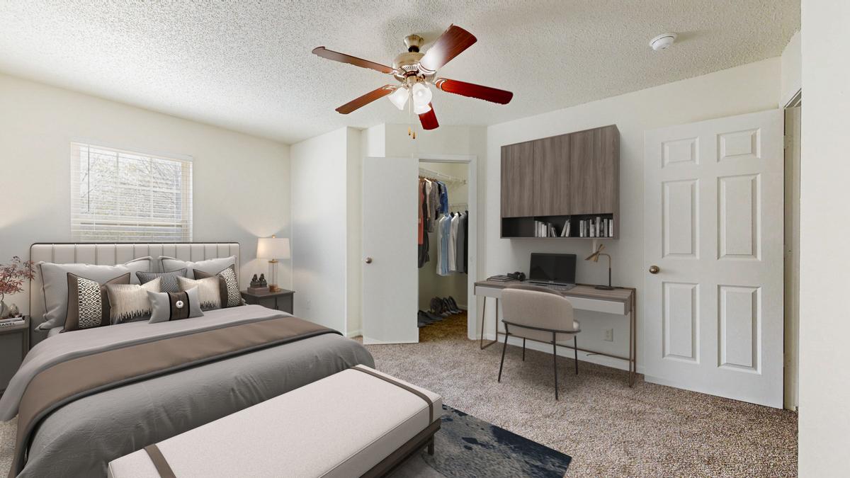 A bedroom with a bed, desk, and a ceiling fan.