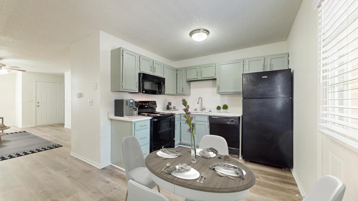 A kitchen with a table set for four.